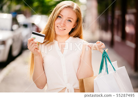 Dreamy woman with credit card and shopping bags 55287495