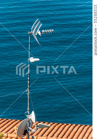 Antennas on the roof of a house by the sea 55288315