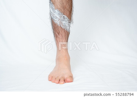 將脫毛膏塗抹在男士腿部脫毛部位的圖像 將脫毛膏塗抹在男士腿部脫毛部位的圖像 55288794