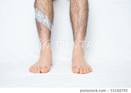 將脫毛膏塗抹在男士腿部脫毛部位的圖像 將脫毛膏塗抹在男士腿部脫毛部位的圖像 55288795