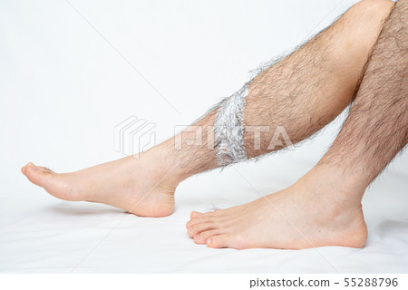 將脫毛膏塗抹在男士腿部脫毛部位的圖像 55288796