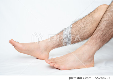 將脫毛膏塗抹在男士腿部脫毛部位的圖像 55288797