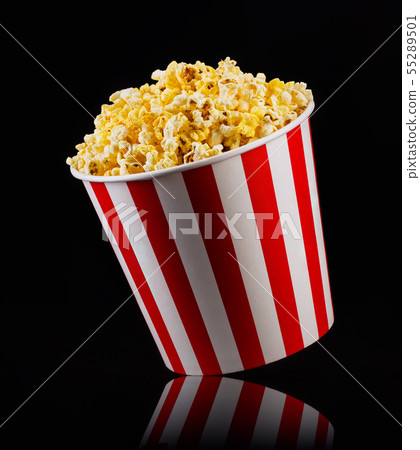 Paper striped bucket with popcorn isolated on black background Paper striped bucket with popcorn isolated on black background 55289501