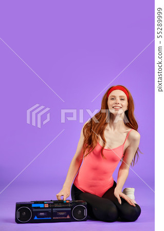 athletic female trainer sits near portable retro audio player ready to start dance class athletic female trainer sits near portable retro audio player ready to start dance class 55289999