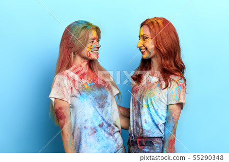 girls with satisfied expressions standing isolated over blue background 55290348