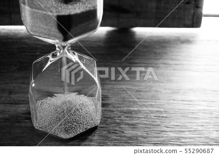 Mono tone sandhour on the table near the window. Mono tone sandhour on the table near the window. 55290687