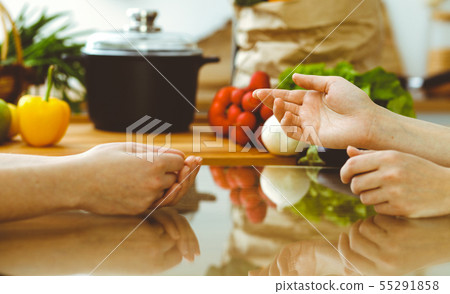 Closeup of human hands discussing something while cooking in kitchen. Women talking about menu Closeup of human hands discussing something while cooking in kitchen. Women talking about menu 55291858