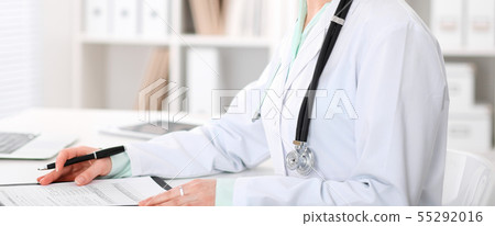 Doctor woman sitting at the desk with computer at workplace in hospital office. Unknown physician's 55292016