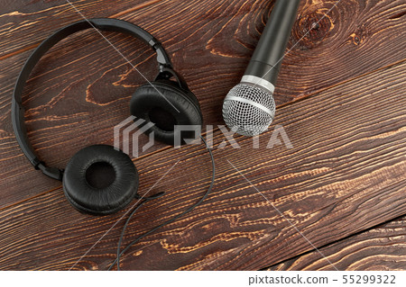 Microphone and headphones on brown wooden background. 55299322