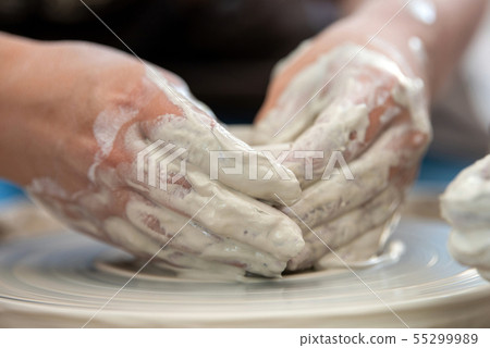 Potter makes pottery dishes on potter's wheel 55299989