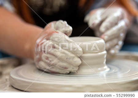 Potter makes pottery dishes on potter's wheel 55299990