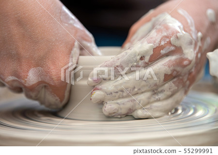 Potter makes pottery dishes on potter's wheel 55299991