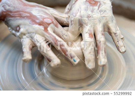 Potter makes pottery dishes on potter's wheel 55299992