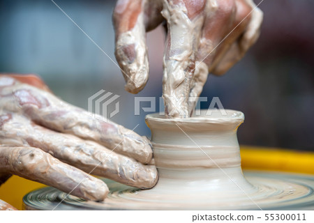 Potter makes pottery dishes on potter's wheel 55300011