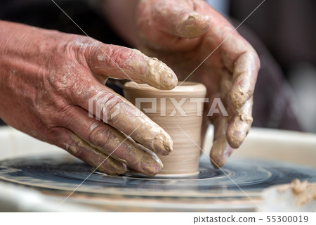 Potter makes pottery dishes on potter's wheel Potter makes pottery dishes on potter's wheel 55300019