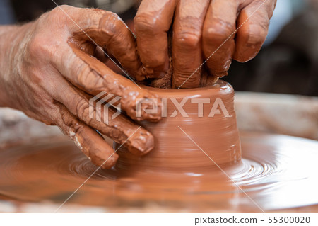 Potter makes pottery dishes on potter's wheel 55300020
