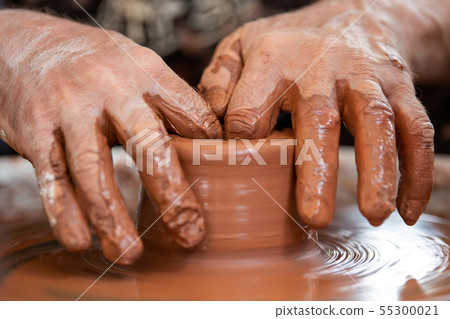 Potter makes pottery dishes on potter's wheel Potter makes pottery dishes on potter's wheel 55300021
