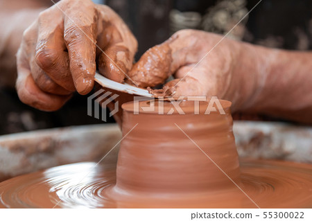 Potter makes pottery dishes on potter's wheel Potter makes pottery dishes on potter's wheel 55300022