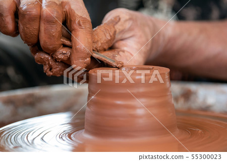 Potter makes pottery dishes on potter's wheel Potter makes pottery dishes on potter's wheel 55300023