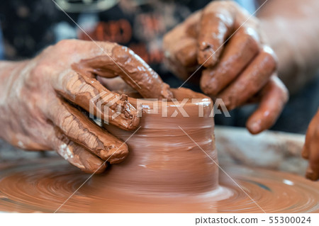 Potter makes pottery dishes on potter's wheel Potter makes pottery dishes on potter's wheel 55300024
