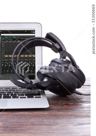Laptop and headphones on wooden background. Laptop and headphones on wooden background. 55300669