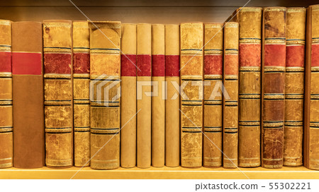 Antique books on wooden bookshelf in library 55302221