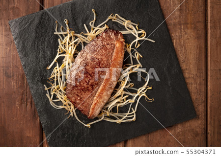 Kobe meat, wagyu beef steak, cooked, with soy bean sprouts, shot from above 55304371