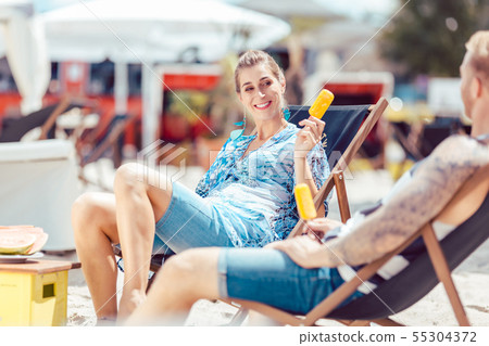 Young couple enjoying popsicle Young couple enjoying popsicle 55304372