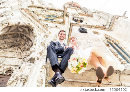 Newly wed couple sitting outside the church 55304502