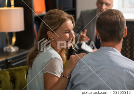 Smiling happy wife sitting next to her husband 55305513