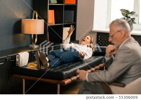 Worried middle-aged Caucasian woman lying on the couch Worried middle-aged Caucasian woman lying on the couch 55306009