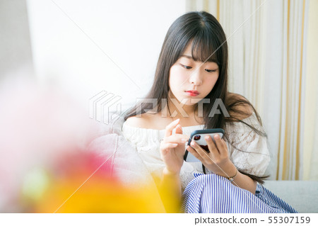 Young girl using smartphone in room 55307159