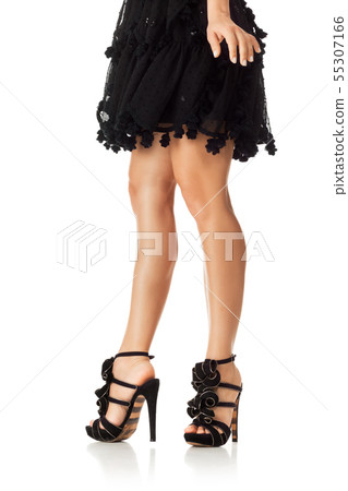Woman in black dress standing in high heels shoes 55307166