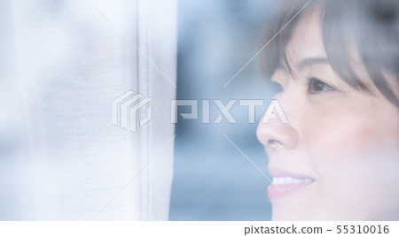 A woman looking out through the window 55310016