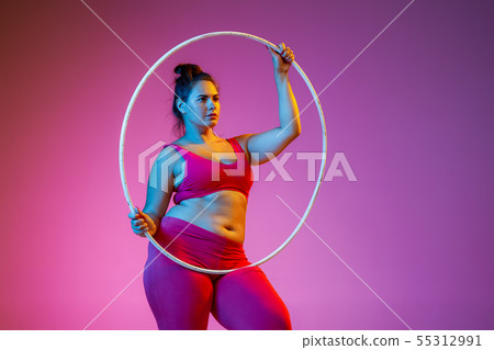 Young caucasian plus size female model's training on gradient background Young caucasian plus size female model's training on gradient background 55312991