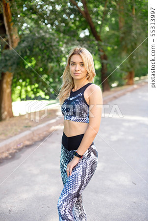Young slim woman with a sporty body, long blond hair, dressed in a sports top and leggings, prepares Young slim woman with a sporty body, long blond hair, dressed in a sports top and leggings, prepares 55313997