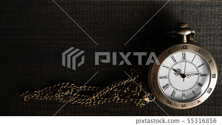 Antique pocket watch Placed on a black wooden 55316856