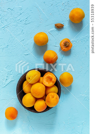 Ripe apricots in a black wooden bowl. Ripe apricots in a black wooden bowl. 55318939
