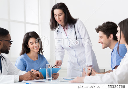 Chief doctor discussing diagnosis with interns and practitioners 55320766