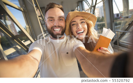 Travelling concept. Couple making selfie at airport terminal Travelling concept. Couple making selfie at airport terminal 55320792