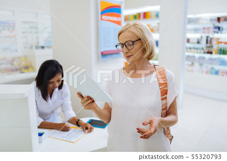 Cheerful blonde female person reading her notes 55320793