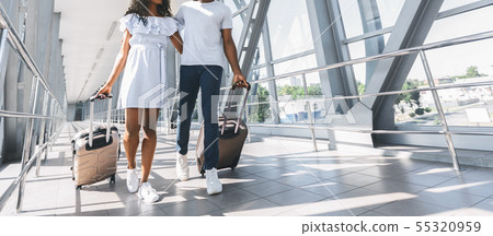 African couple walking with luggage in airport African couple walking with luggage in airport 55320959