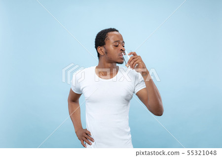 Half-length close up portrait of young man on blue background. Half-length close up portrait of young man on blue background. 55321048
