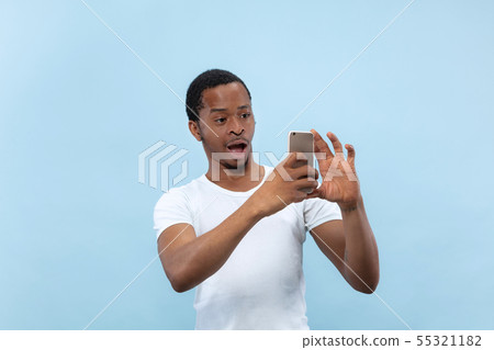 Half-length close up portrait of young man on blue background. Half-length close up portrait of young man on blue background. 55321182