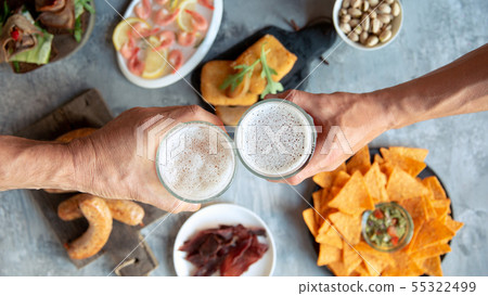 Top view of beer glasses with foam on top and delicious snacks Top view of beer glasses with foam on top and delicious snacks 55322499