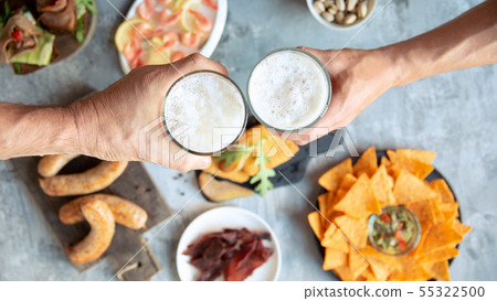 Top view of beer glasses with foam on top and delicious snacks Top view of beer glasses with foam on top and delicious snacks 55322500