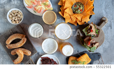 Top view of beer glasses with foam on top and delicious snacks Top view of beer glasses with foam on top and delicious snacks 55322501
