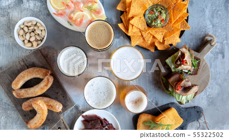Top view of beer glasses with foam on top and delicious snacks 55322502
