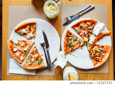 friends eating pizza in a indoor cafe 55327725