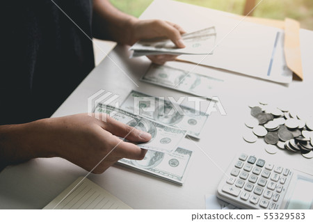 Asian men are holding banknotes in cash and placed 55329583